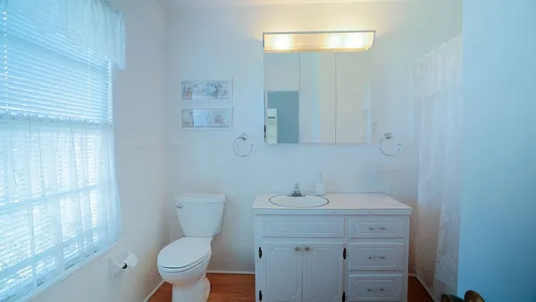 a bathroom with a toilet sink and mirror