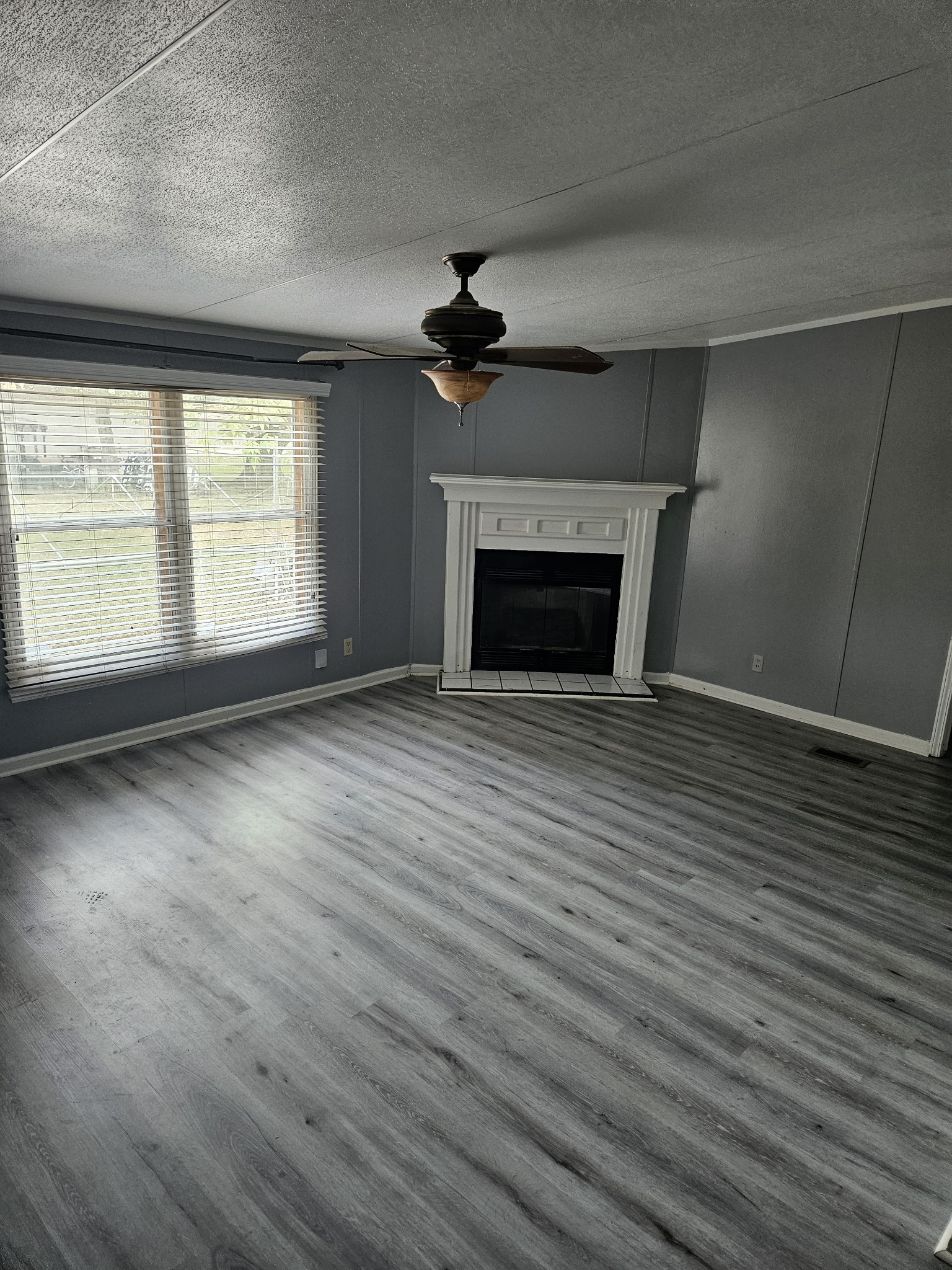 1610 Texas Street Alvin, TX 77511 - Photo 17 of 22 an empty room with wooden floor fireplace and windows