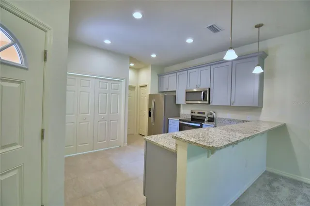 a kitchen with stainless steel appliances granite countertop a refrigerator stove a sink and dishwasher