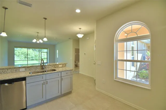 a bathroom with a granite countertop sink a large mirror and a window