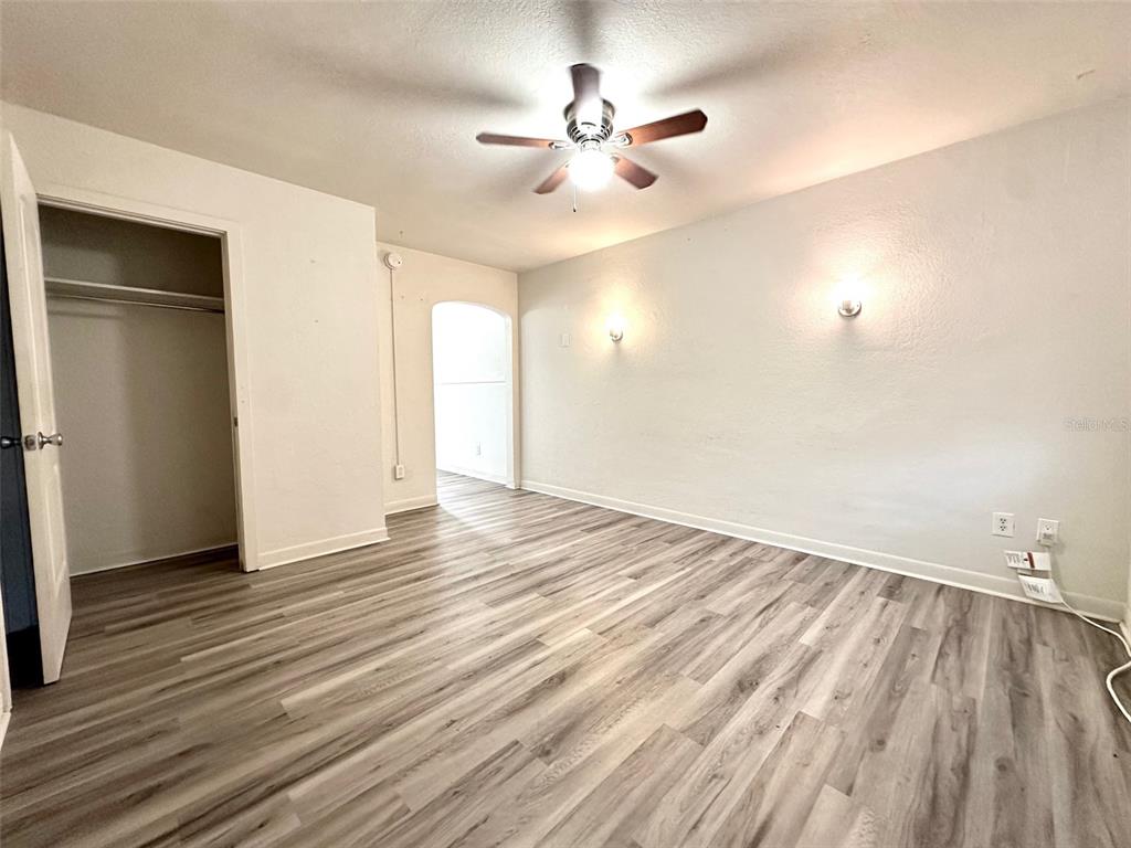 1102 Sunset Point Road, Unit 2 Clearwater, FL 33755 - Photo 2 of 11 an empty room with wooden floor and windows