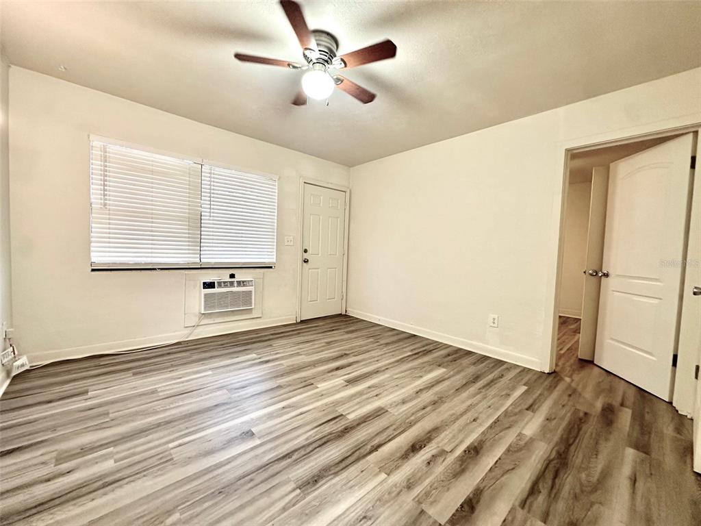 1102 Sunset Point Road, Unit 2 Clearwater, FL 33755 - Photo 3 of 11 a view of an empty room with wooden floor and a window