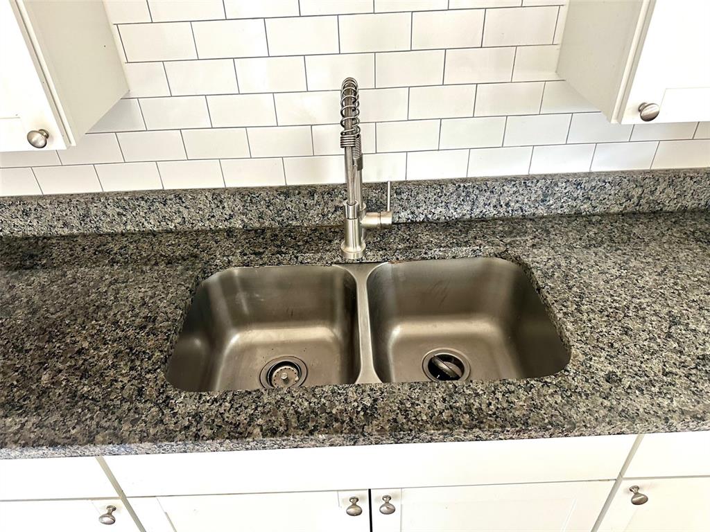 1102 Sunset Point Road, Unit 2 Clearwater, FL 33755 - Photo 5 of 11 a kitchen sink with a granite countertop white sink and a granite counter top