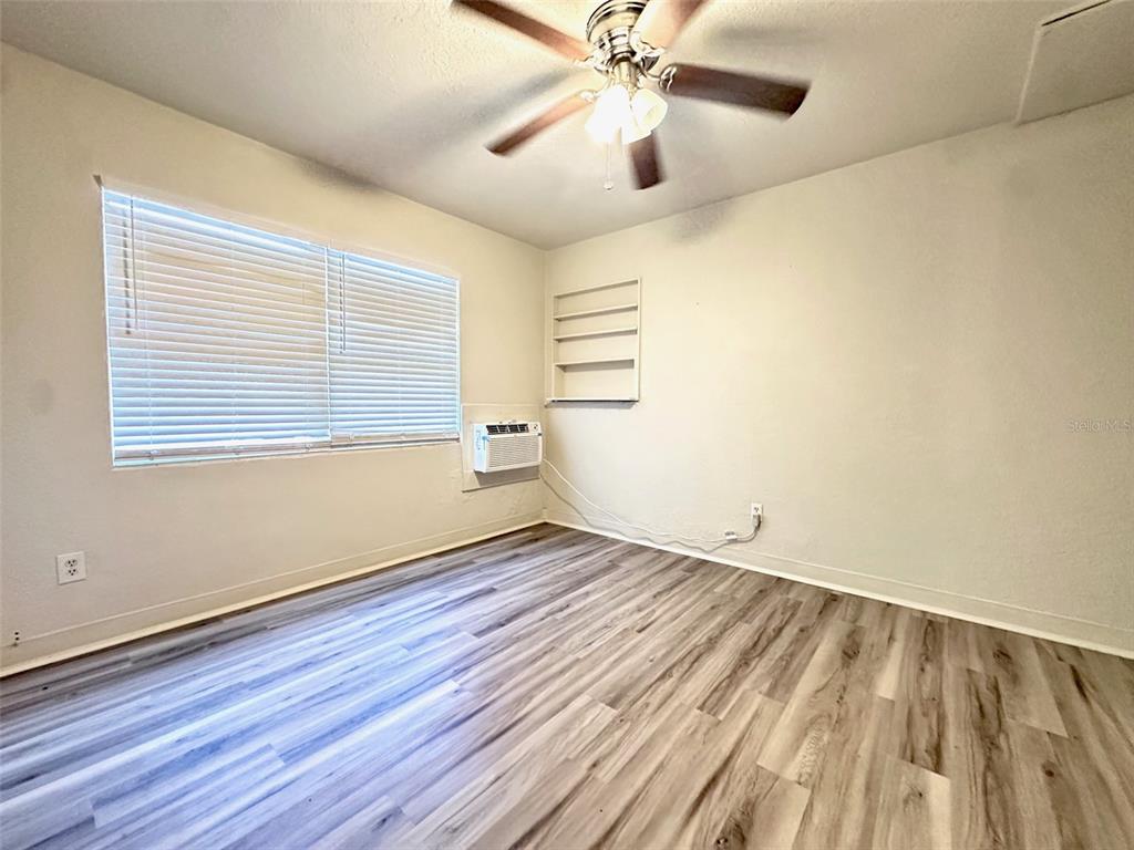 1102 Sunset Point Road, Unit 2 Clearwater, FL 33755 - Photo 6 of 11 an empty room with wooden floor chandelier fan and windows