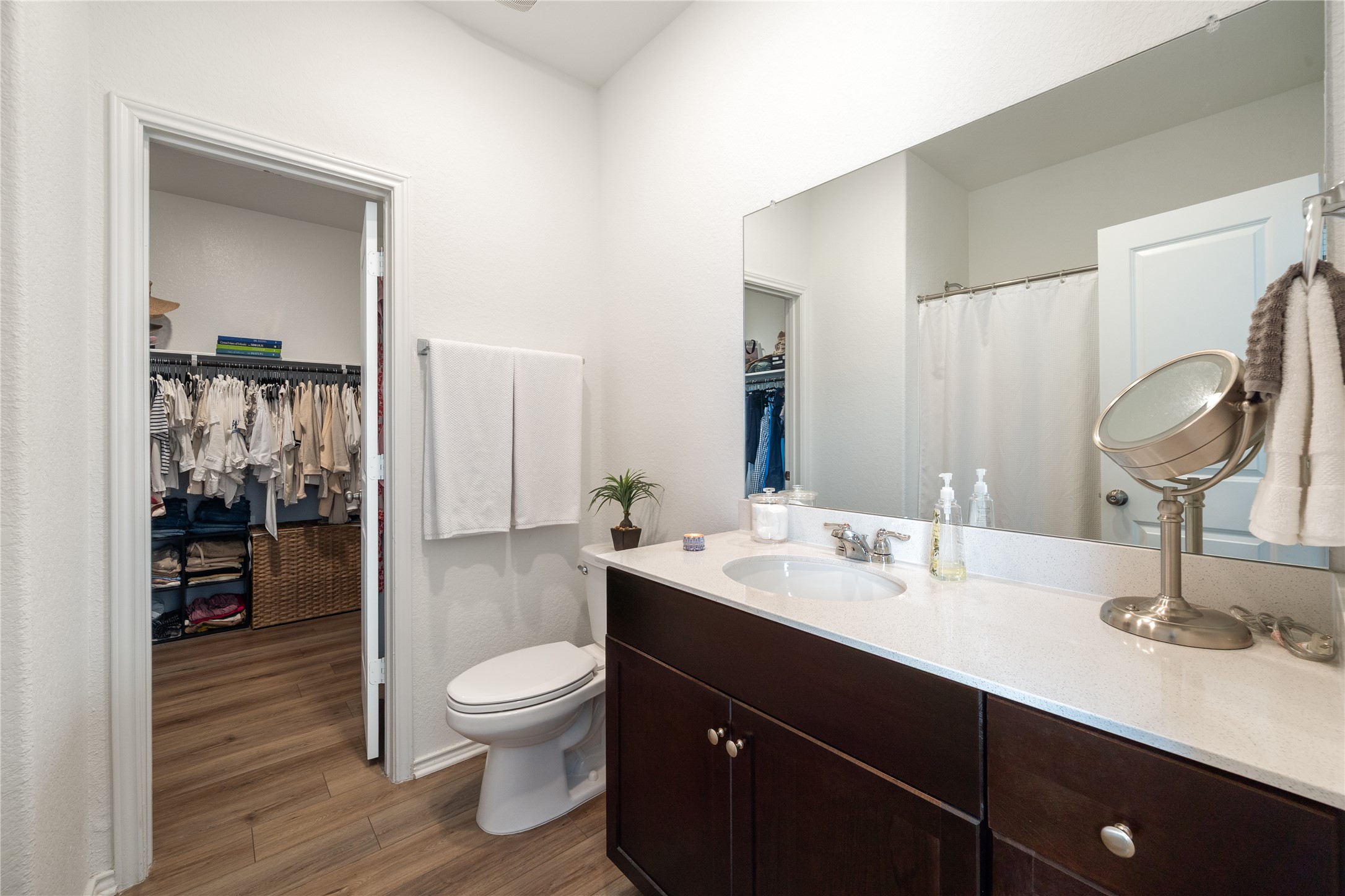 14404 Berning Road Manor, TX 78653 - Photo 19 of 38 A streamlined vanity with a single sink anchors this well-appointed bathroom, featuring convenient access to an adjacent walk-in closet.