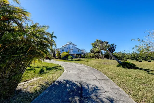an aerial view of a house with a yard and lake view