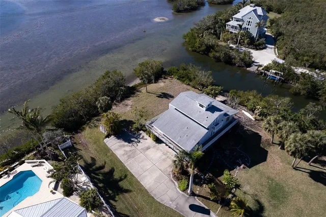 an aerial view of a house with a yard and lake view