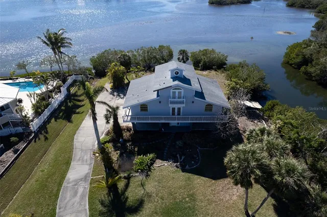 an aerial view of a house with yard and lake view