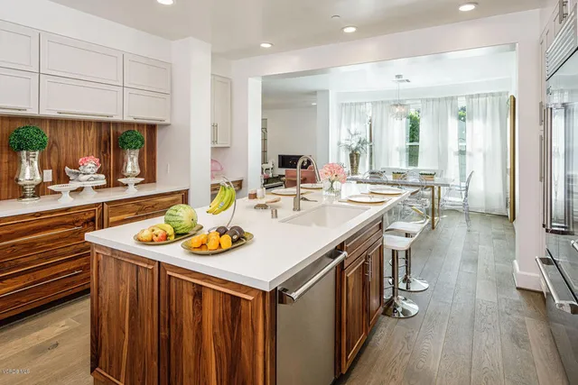 a dining hall with stainless steel appliances granite countertop a stove and a dining table with wooden floor