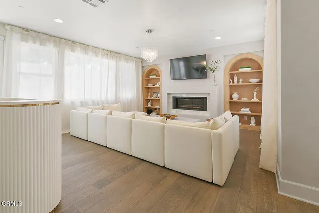 a spacious bedroom with a bed a chandelier and a large window
