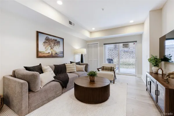 a living room with furniture and a potted plant