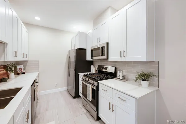 a kitchen with white cabinets stainless steel appliances and sink