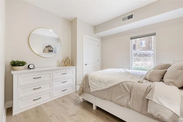 a bedroom with a bed and a mirror on dresser