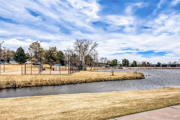 a view of swimming pool with lake and houses in the back
