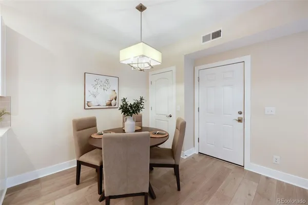 a dining room with furniture a chandelier and wooden floor