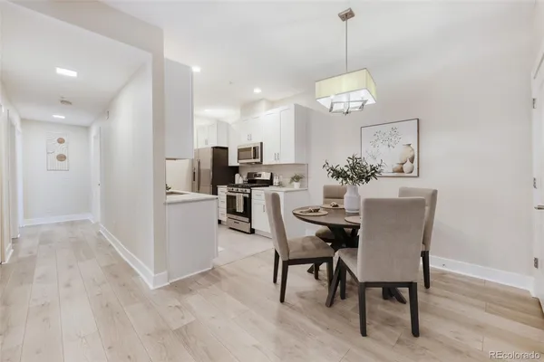 a dining room with wooden floor a chandelier a wooden table and chairs