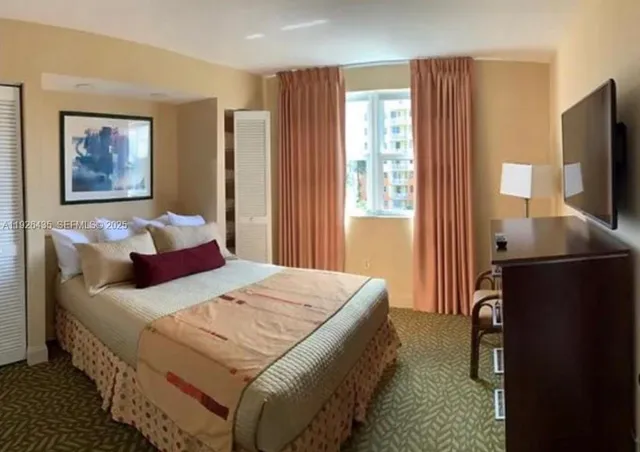 a bedroom with a bed and a flat screen television