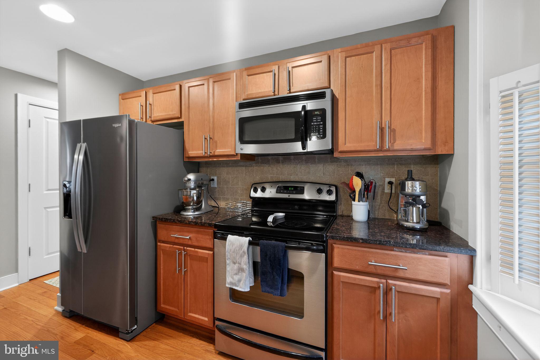 4300 Spruce Street, Unit B304 Philadelphia, PA 19104 - Photo 16 of 26 a kitchen with stainless steel appliances granite countertop a refrigerator stove and sink