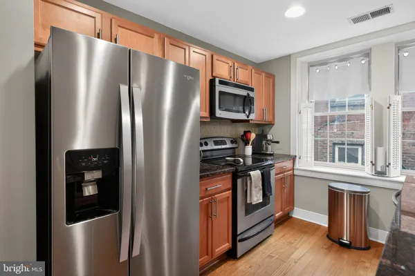 a kitchen with stainless steel appliances granite countertop a refrigerator stove and sink