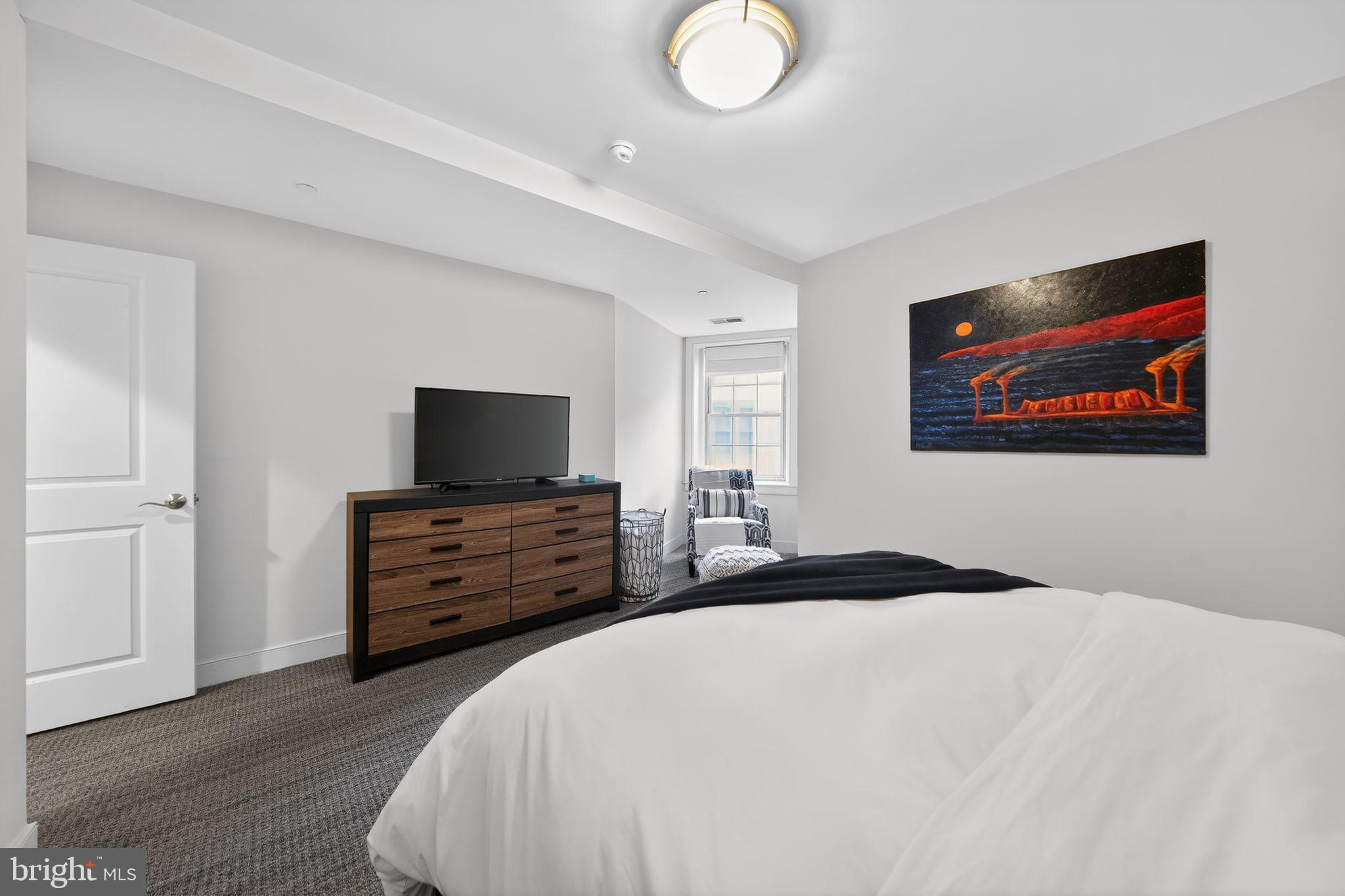 4300 Spruce Street, Unit B304 Philadelphia, PA 19104 - Photo 18 of 26 a bedroom with a bed and a flat screen tv