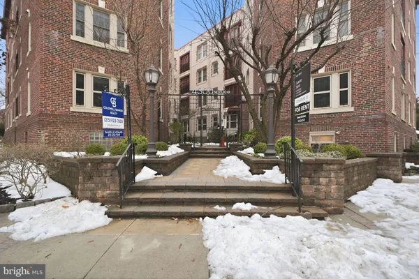 a front view of a building with cars parked