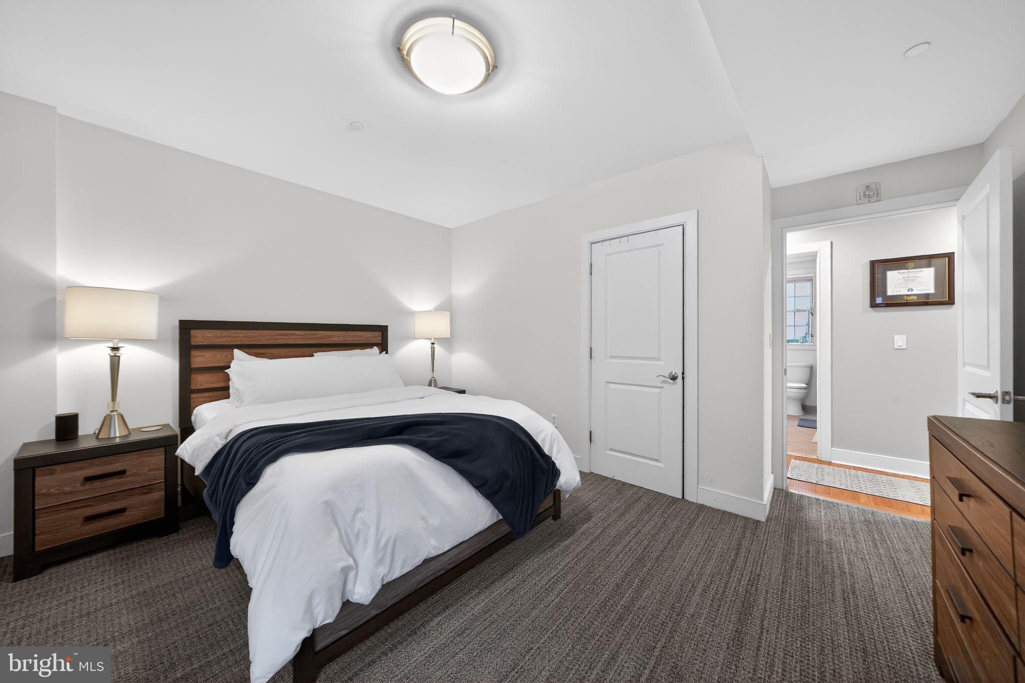 4300 Spruce Street, Unit B304 Philadelphia, PA 19104 - Photo 21 of 26 a bedroom with a bed and a chandelier