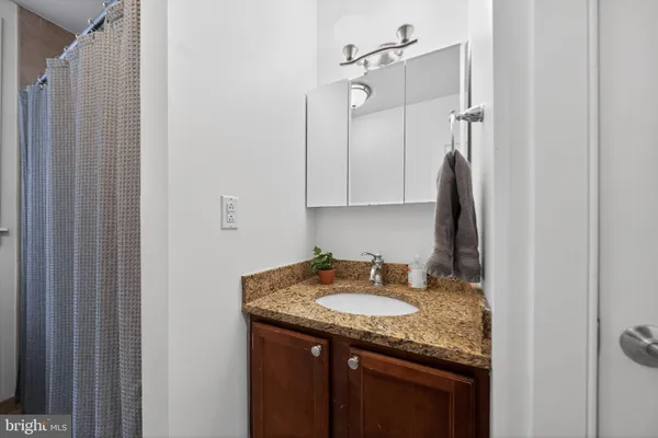 a bathroom with a granite countertop sink and a mirror