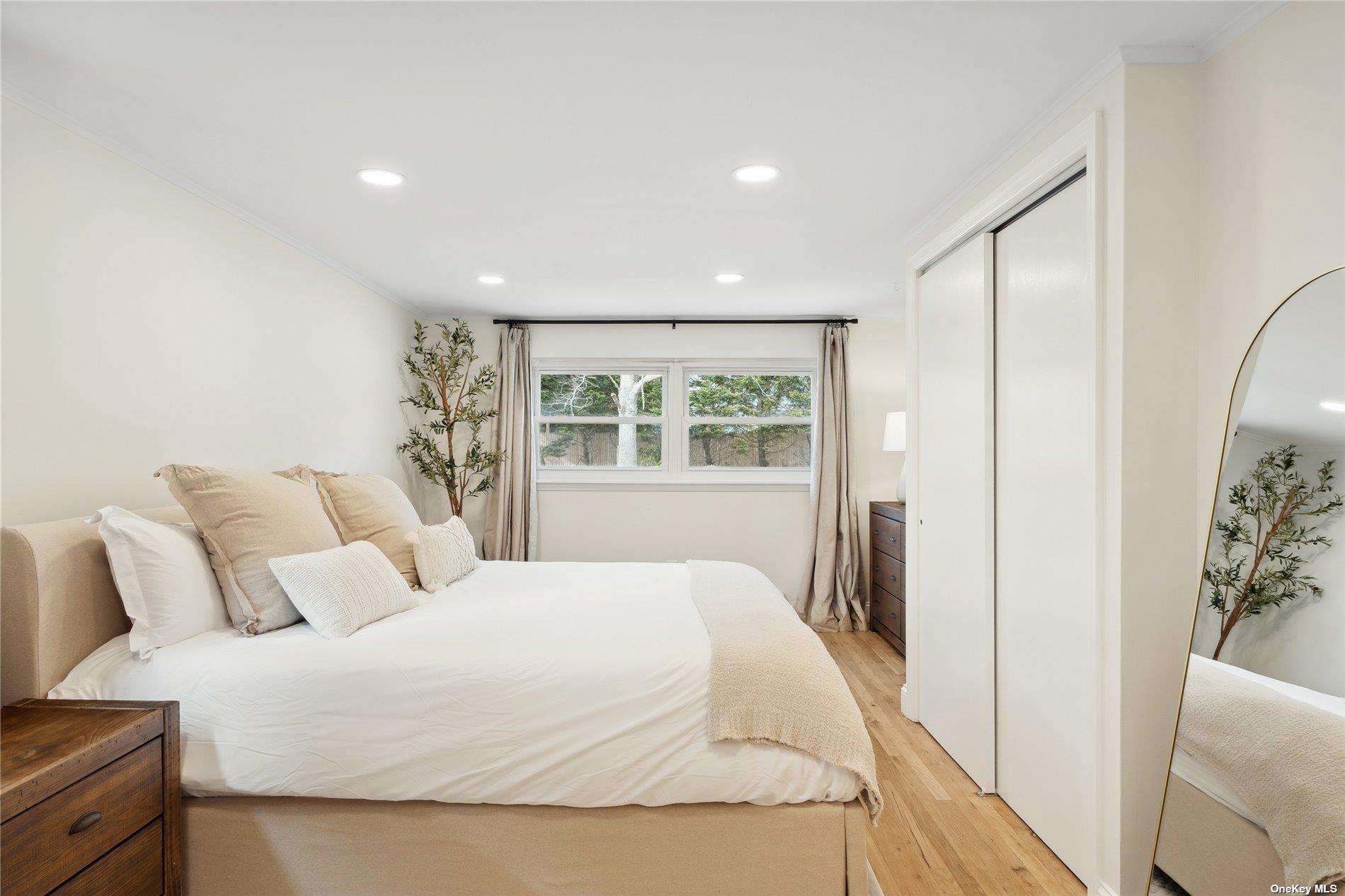 28 Argonne Road West Hampton Bays, NY 11946 - Photo 11 of 24 a bedroom with a large bed and a window