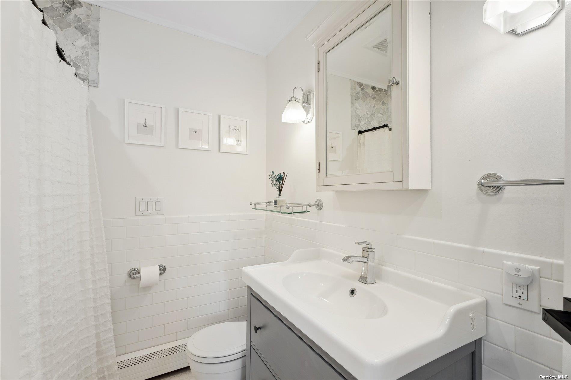 28 Argonne Road West Hampton Bays, NY 11946 - Photo 13 of 24 a bathroom with a sink a toilet and a mirror