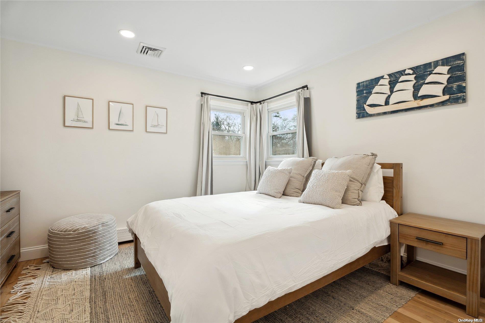 28 Argonne Road West Hampton Bays, NY 11946 - Photo 16 of 24 a bedroom with a bed and wooden floor