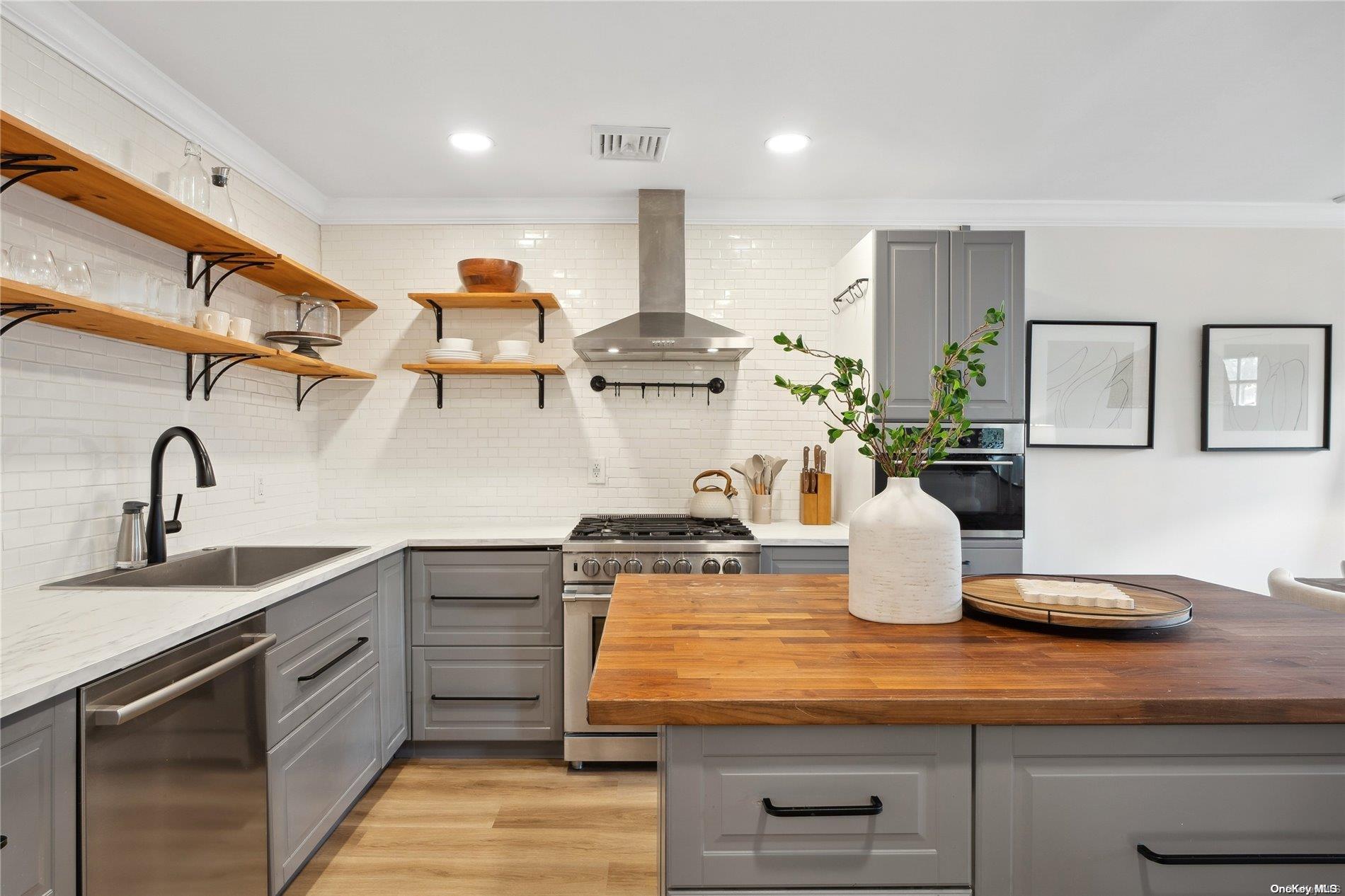 28 Argonne Road West Hampton Bays, NY 11946 - Photo 2 of 24 a kitchen with kitchen island cabinets a sink and appliances
