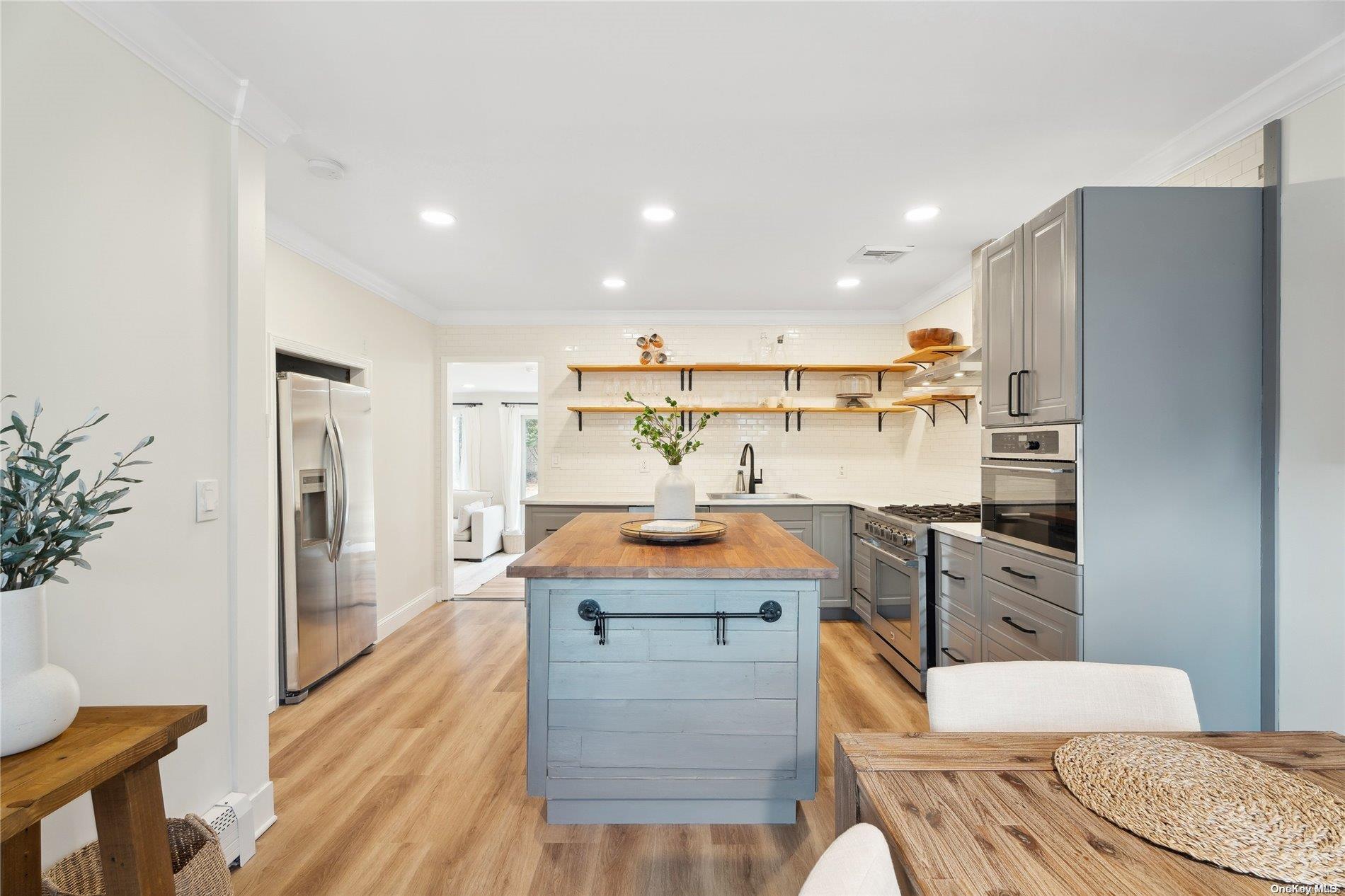 28 Argonne Road West Hampton Bays, NY 11946 - Photo 7 of 24 a kitchen with stainless steel appliances granite countertop a sink stove and refrigerator
