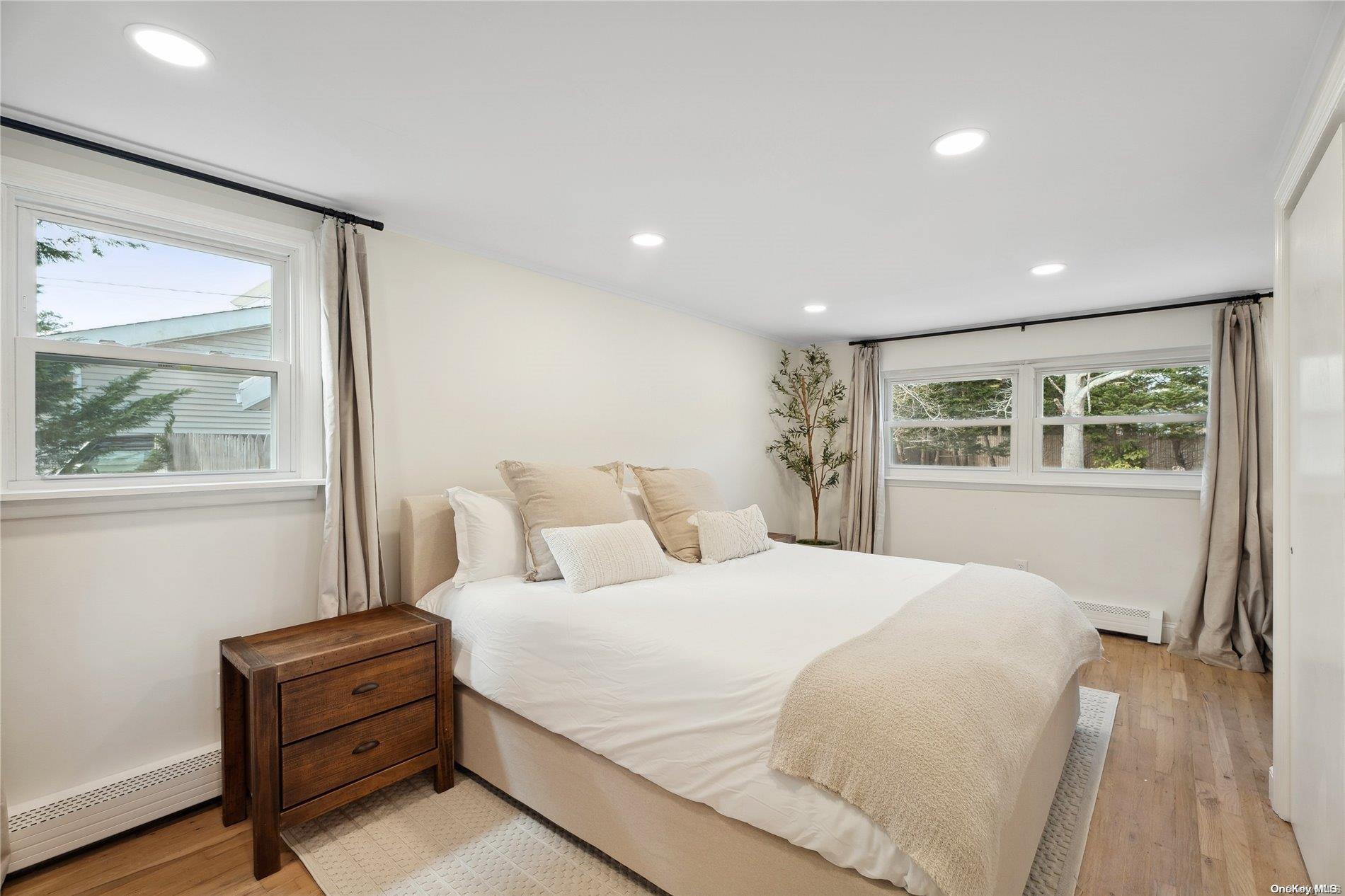 28 Argonne Road West Hampton Bays, NY 11946 - Photo 10 of 24 a bedroom with a large bed and a window