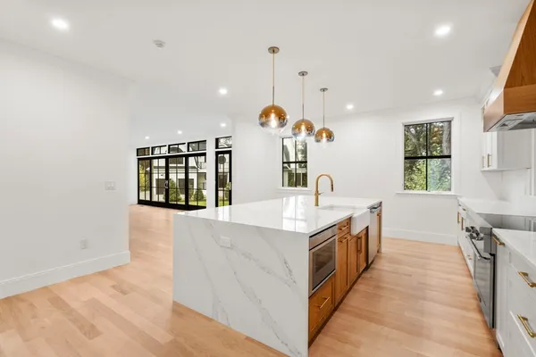 a kitchen with granite countertop a sink a counter top space and cabinets
