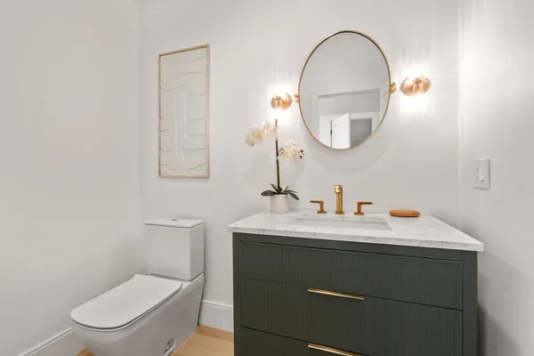 a bathroom with a toilet a sink and a mirror