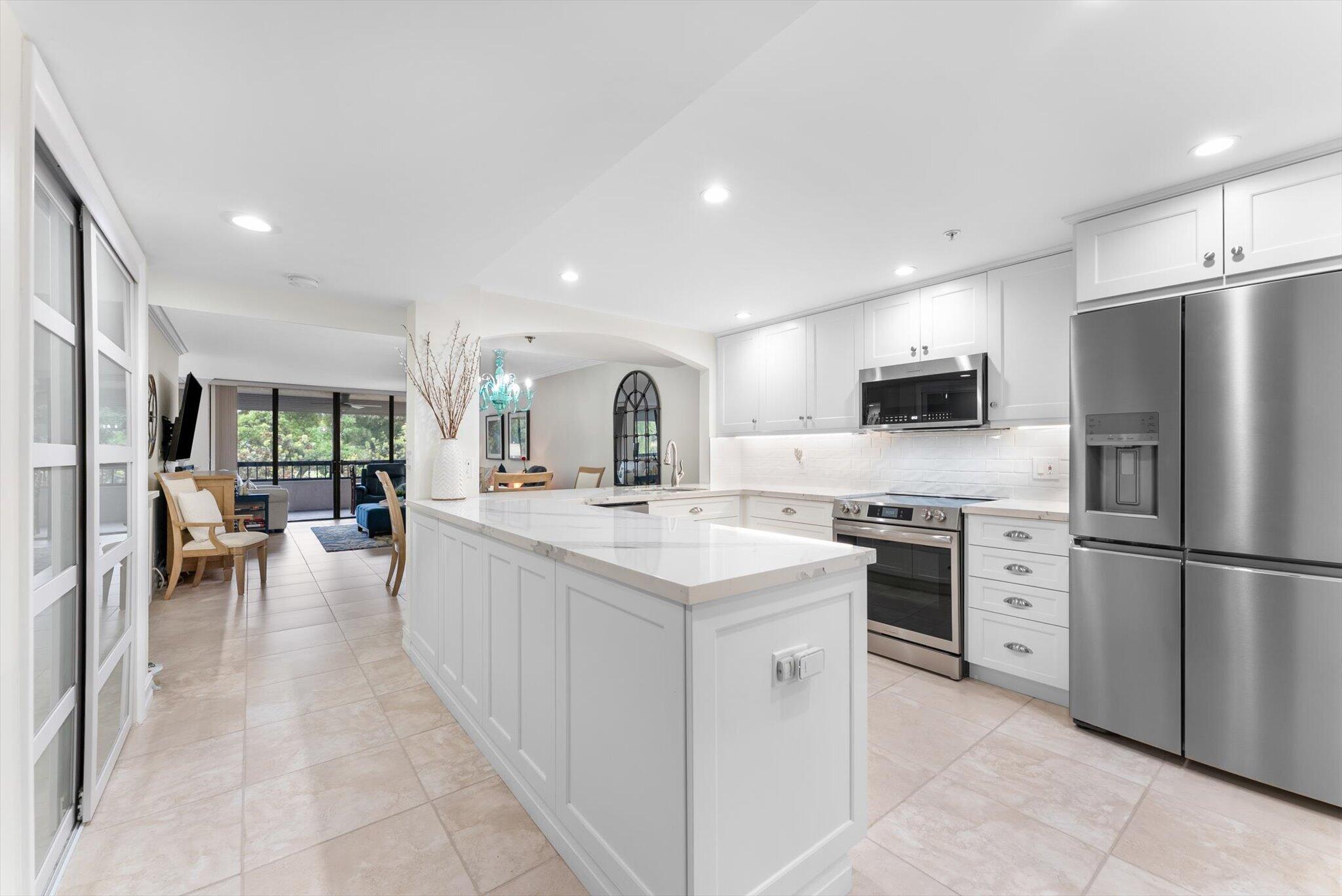 6420 Boca Del Mar Drive, Unit 201 Boca Raton, FL 33433 - Photo 1 of 45 a kitchen with stainless steel appliances granite countertop a refrigerator oven a sink dishwasher and white cabinets with wooden floor