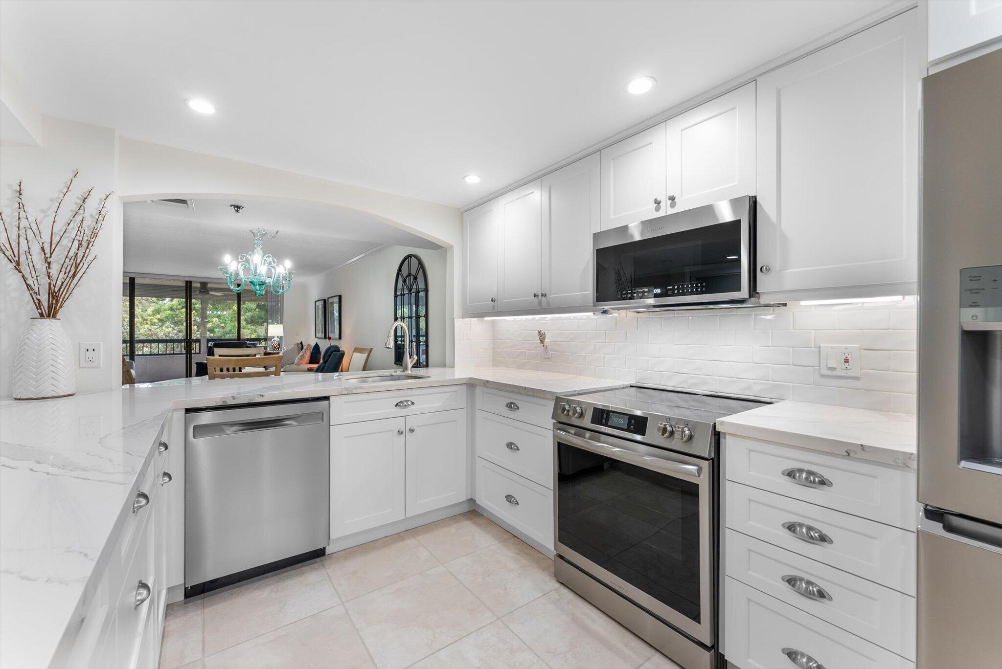 6420 Boca Del Mar Drive, Unit 201 Boca Raton, FL 33433 - Photo 2 of 45 a kitchen with white cabinets and stainless steel appliances