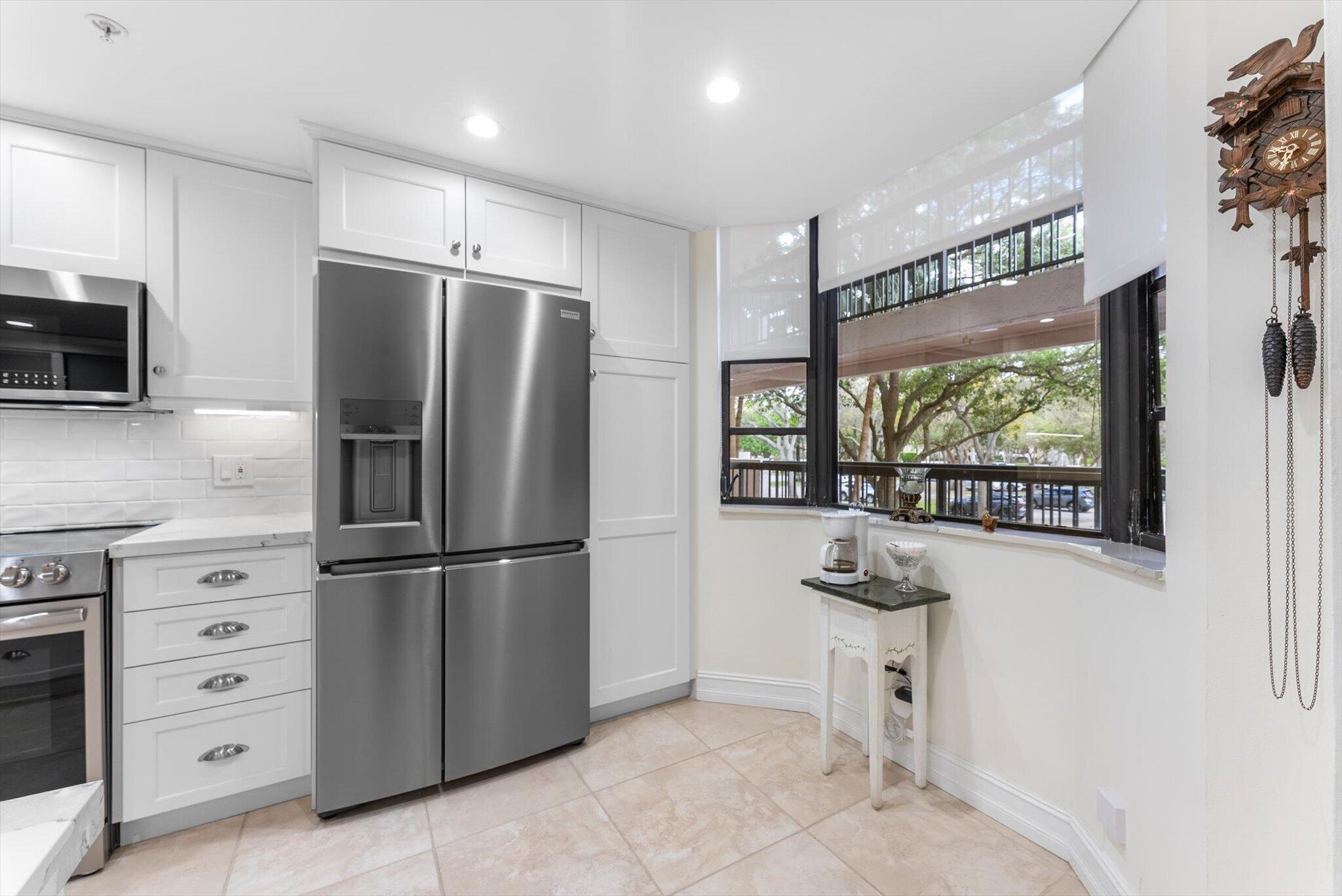 6420 Boca Del Mar Drive, Unit 201 Boca Raton, FL 33433 - Photo 3 of 45 a kitchen with stainless steel appliances kitchen island granite countertop a refrigerator and a stove top oven