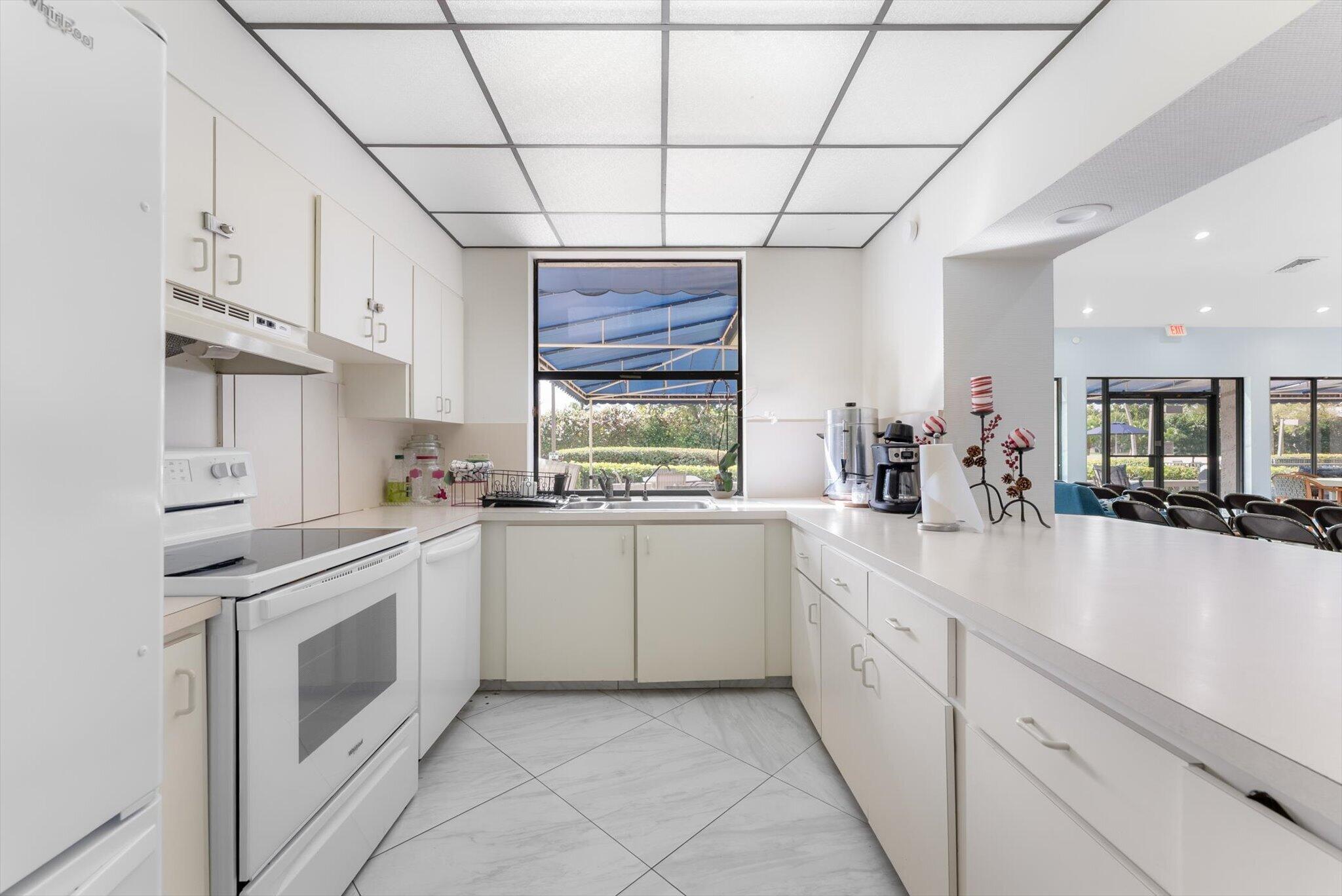 6420 Boca Del Mar Drive, Unit 201 Boca Raton, FL 33433 - Photo 36 of 45 a kitchen with white cabinets and white appliances