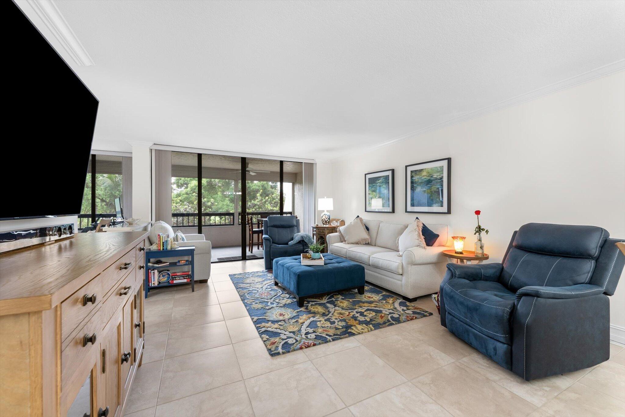 6420 Boca Del Mar Drive, Unit 201 Boca Raton, FL 33433 - Photo 7 of 45 a living room with furniture a large window and a flat screen tv