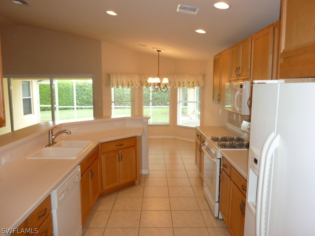19744 Villa Rosa Loop Fort Myers, FL 33967 - Photo 7 of 14 a kitchen with a sink a stove a refrigerator a washer dryer and a dining table