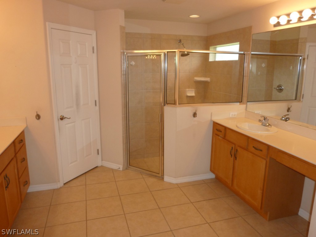 19744 Villa Rosa Loop Fort Myers, FL 33967 - Photo 10 of 14 a bathroom with a sink a mirror and a shower
