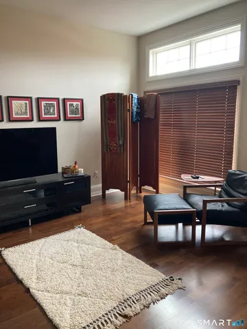 a living room with furniture a flat screen tv and a window