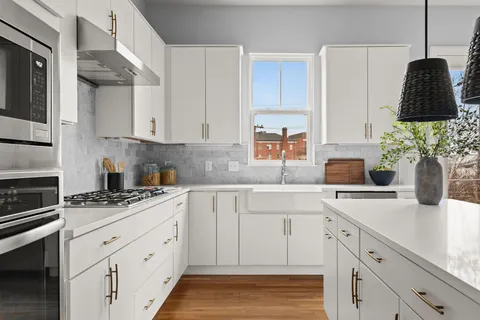 a kitchen with a sink dishwasher and white cabinets