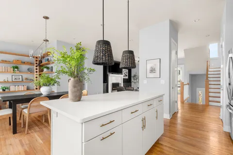 a dining room with furniture potted plants and wooden floor