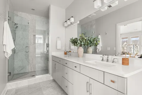 a bathroom with a sink double vanity mirror and bathtub