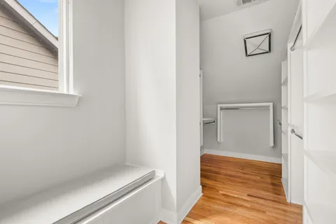 a view of a room with wooden floor and a bathroom