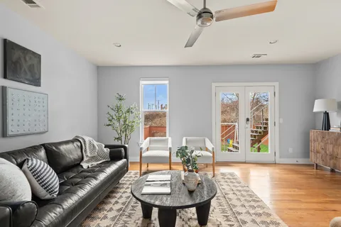 a view of a hallway with wooden floor and a bathroom