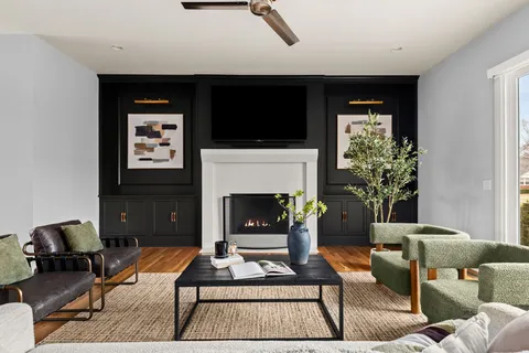 a living room with furniture a flat screen tv and a fireplace
