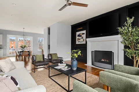 a living room with furniture potted plant a fireplace and a window